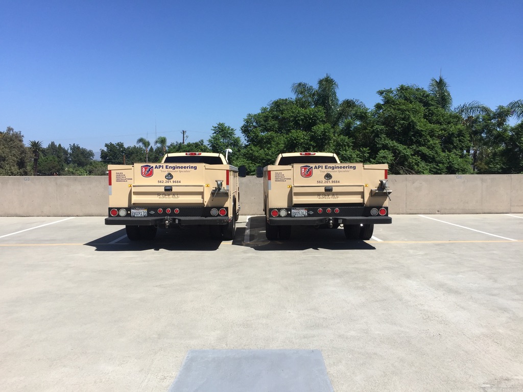 The back of two light beige pickup trucks