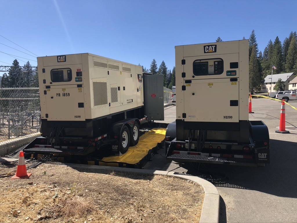 Two medium-sized beige generators placed outdoors