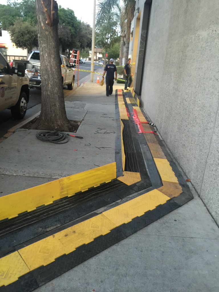 Cable guards placed on a sidewalk to protect the cable wires laid on the sidewalk