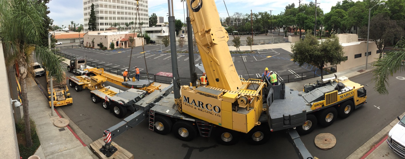 Panoramic view of a road blocked by crane and rigging equipment trucks