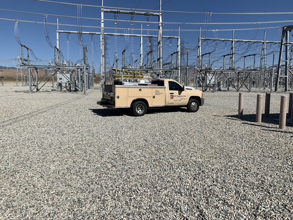 Cream-colored pickup truck parked in the middle of a field of power outposts