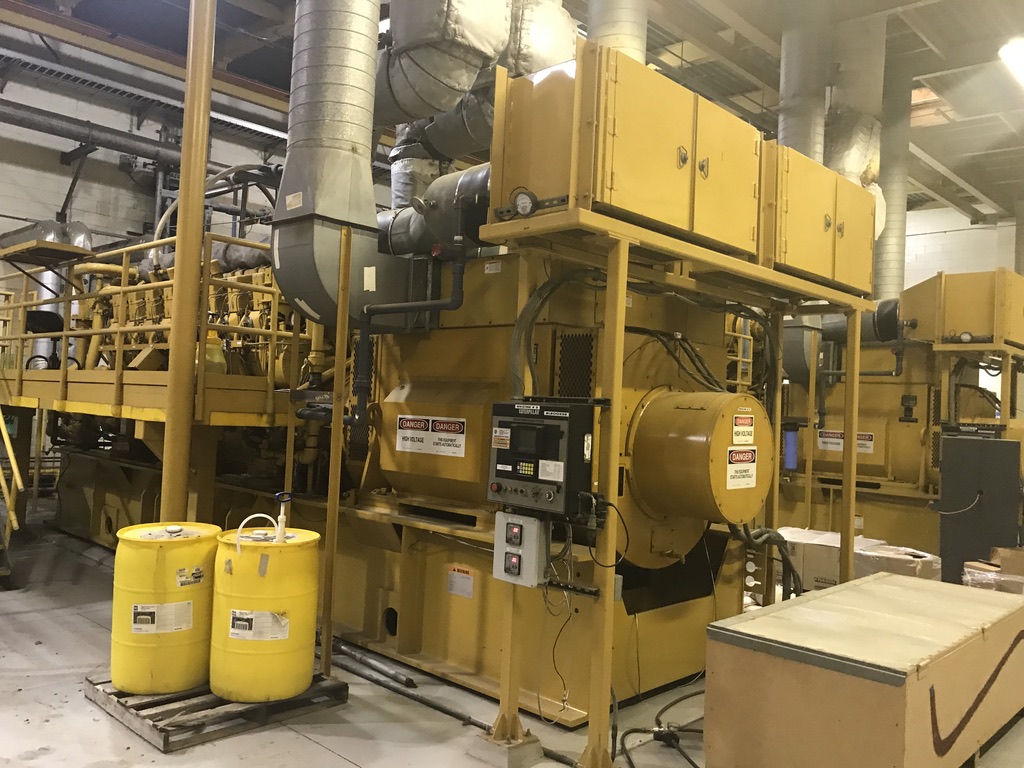 Rows of yellow industrial generators next to yellow plastic containers