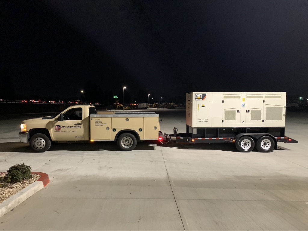 Beige-colored pickup truck with a platform attachment containing a white generator during night time