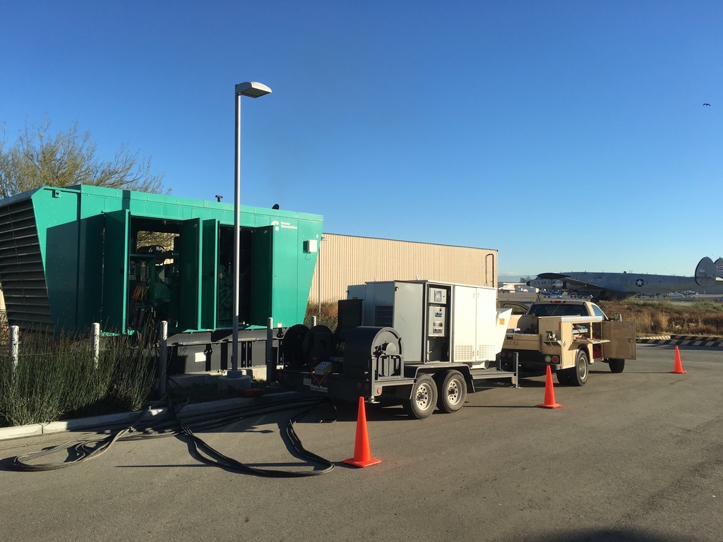 White generator mobile equipment next to a forest green generator equipment