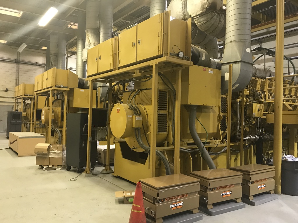 Rows of yellow industrial generators in a building